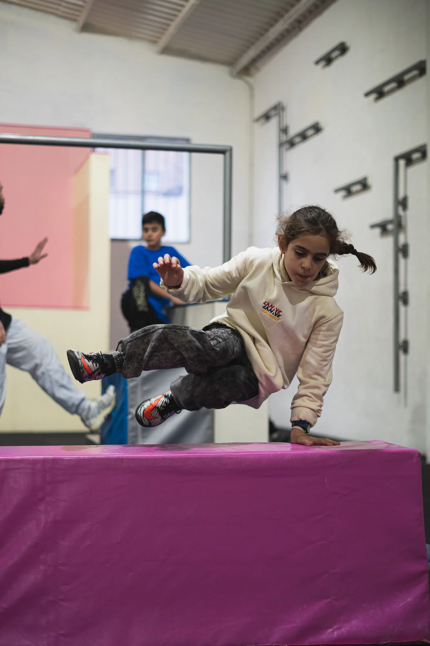 Alumna practicando un paso de obstáculo durante una actividad de parkour infantil
