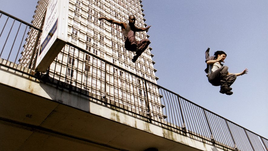 Practicantes de Yamakasi superando un obstáculo urbano
